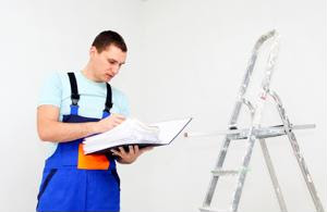 A worker inspects a ladder according to a rulebook.